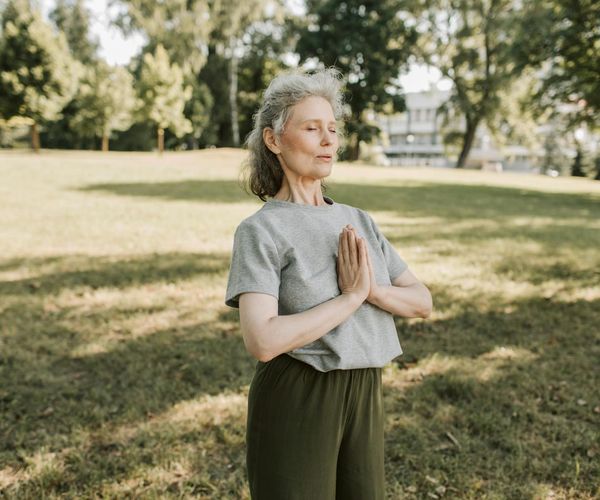 A person meditating peacefully outdoors, embodying tranquility and well-being.